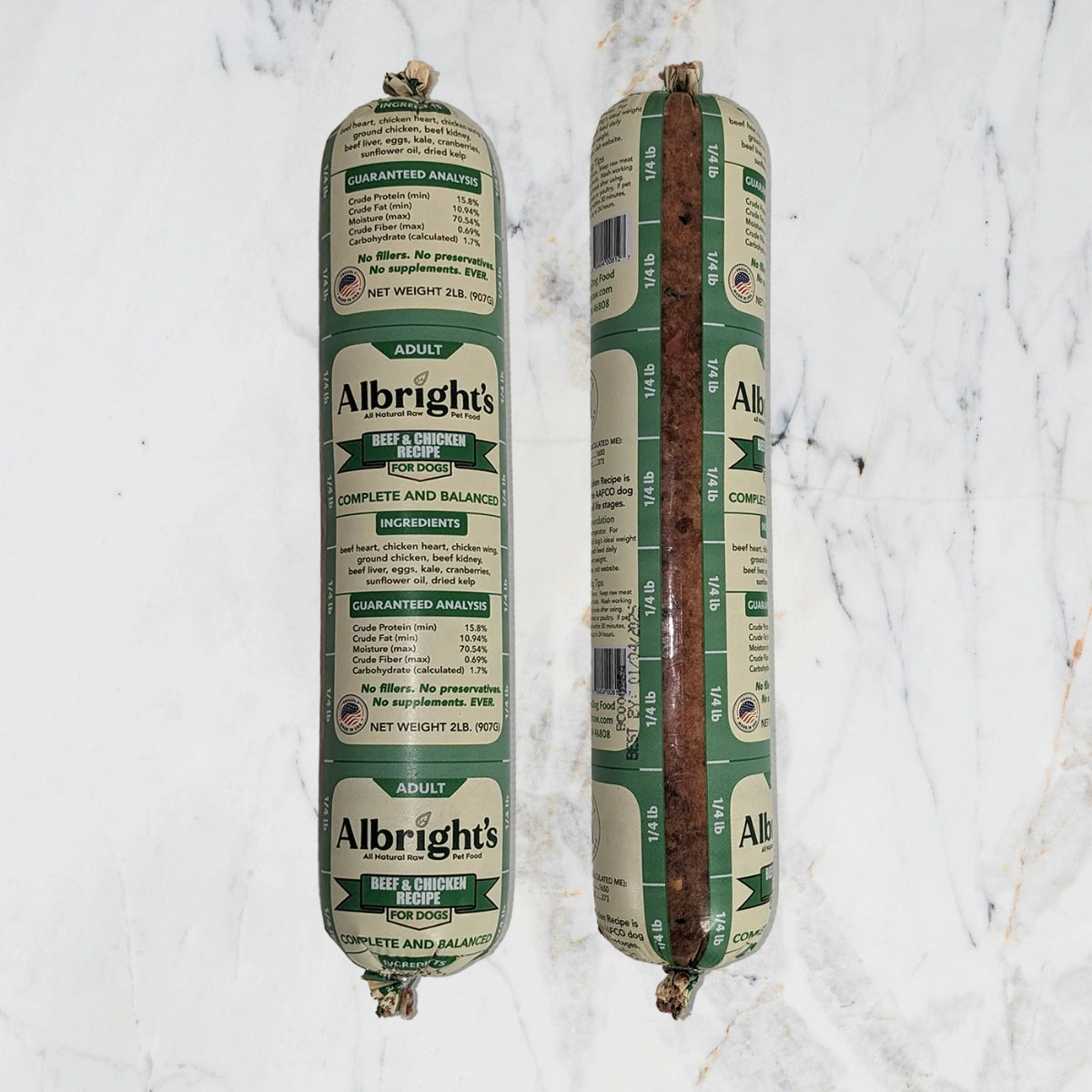 Two packages of Albright's beef and chicken dog food on a marble surface