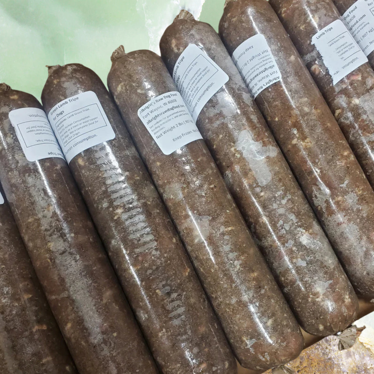 Frozen tubes of Albright’s green lamb tripe raw dog food packaged for dogs, sold by Benny’s Raw Dog Food