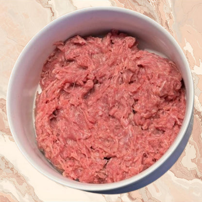 Bowl of raw ground rabbit prey model dog food, part of an 80/10/10 raw diet, sold by Benny’s Raw Dog Food